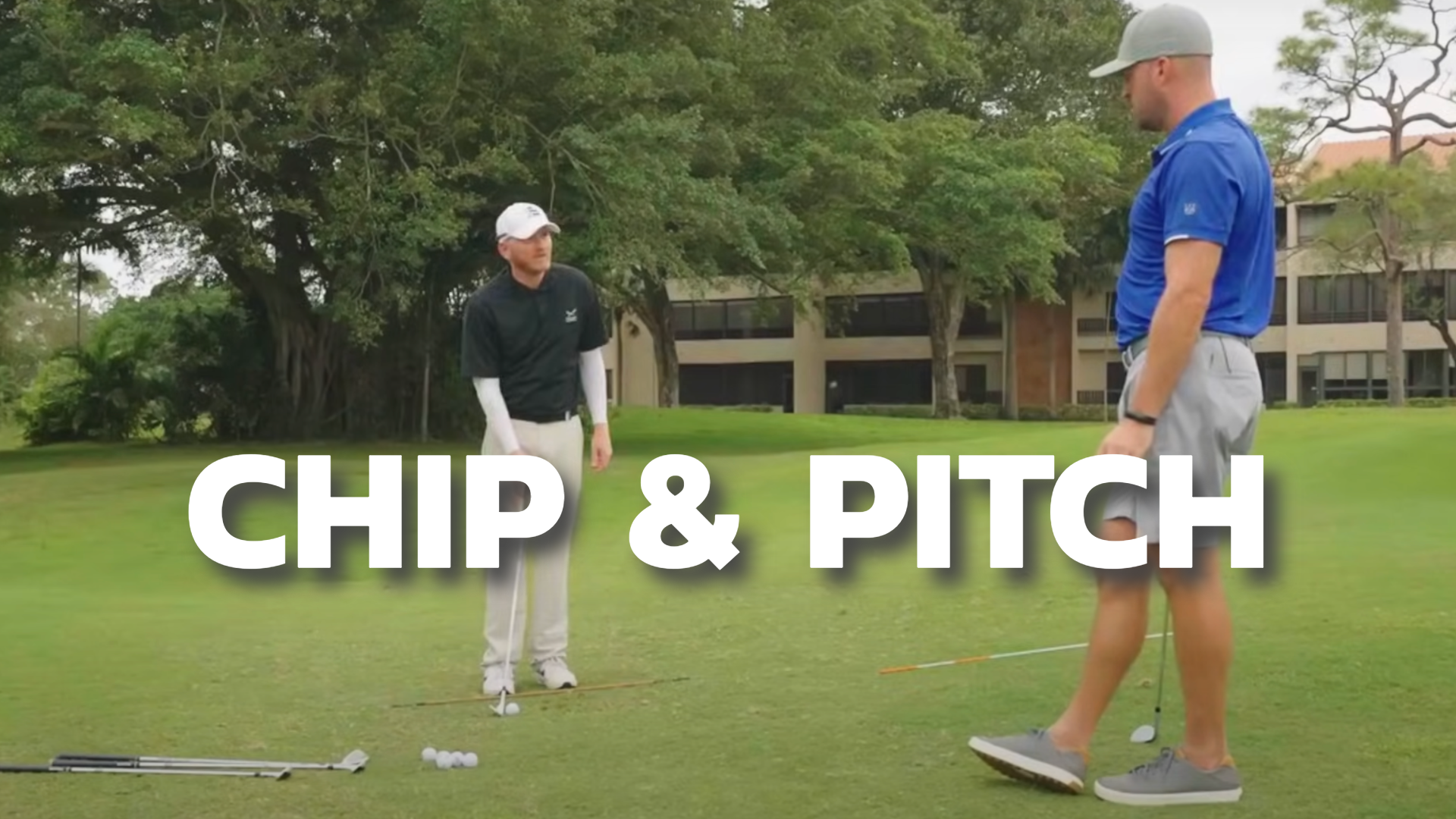 Two golfers on the golf green with alignment sticks, setting up for a chipping and pitching drill.