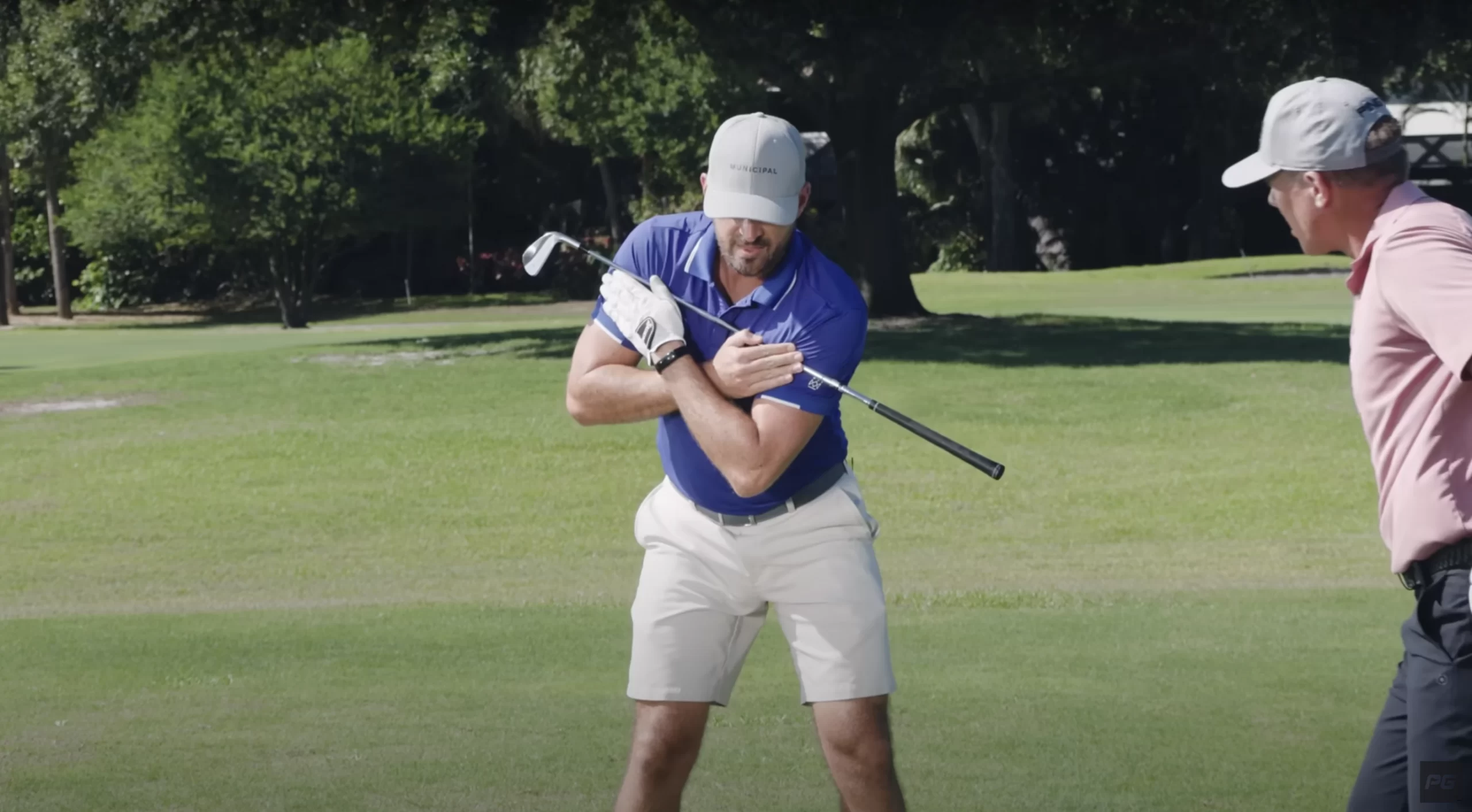 Performance Golf Eric Cogorno holding a golf club across his chest, showcasing the proper shoulder movement of the golf swing.