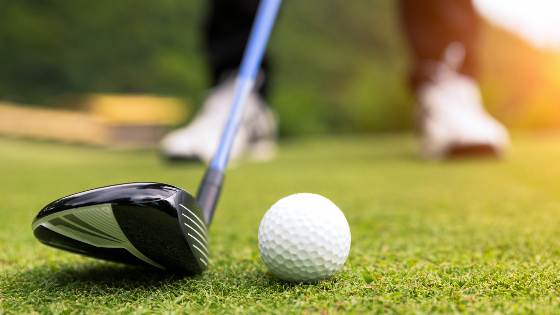 Close up of a golf club driver and a golf ball, showing the distance between the golf ball and the players feet.