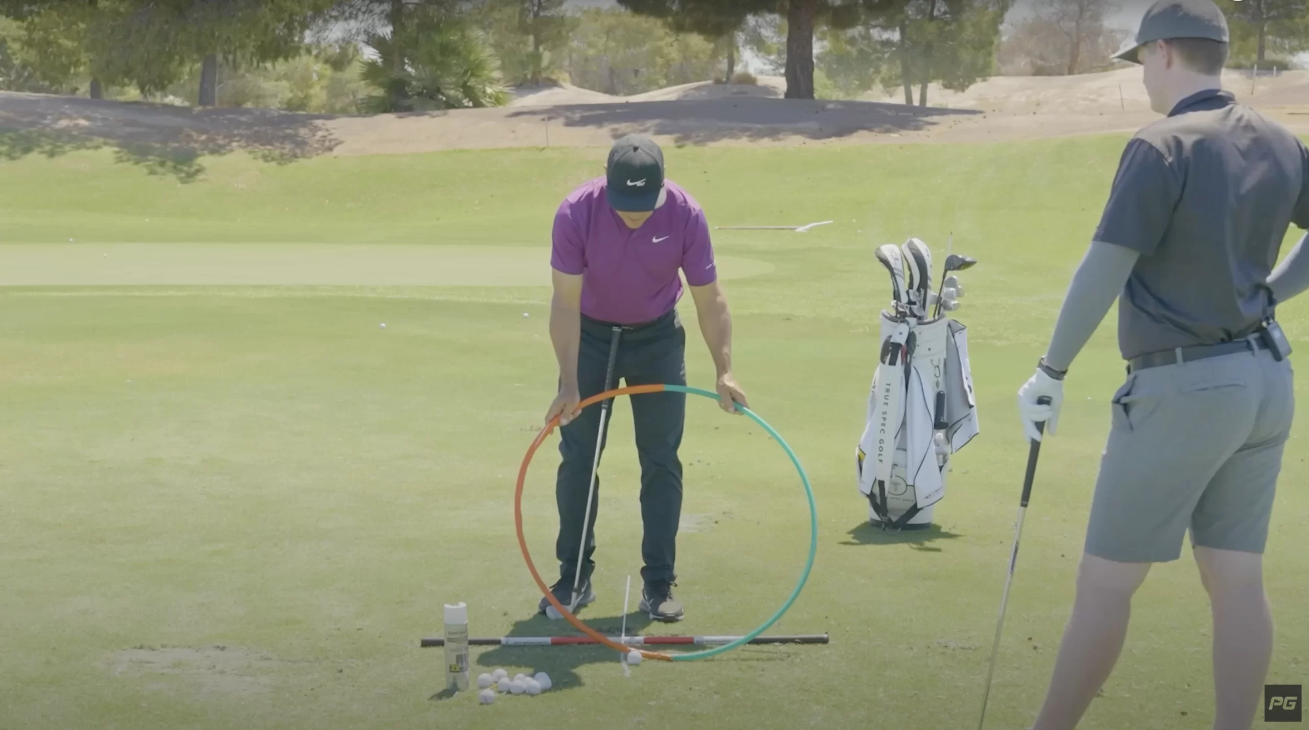 Performance Golf coach Martin Chuck using a hula hoop to demonstrate a golf drill on the golf course.