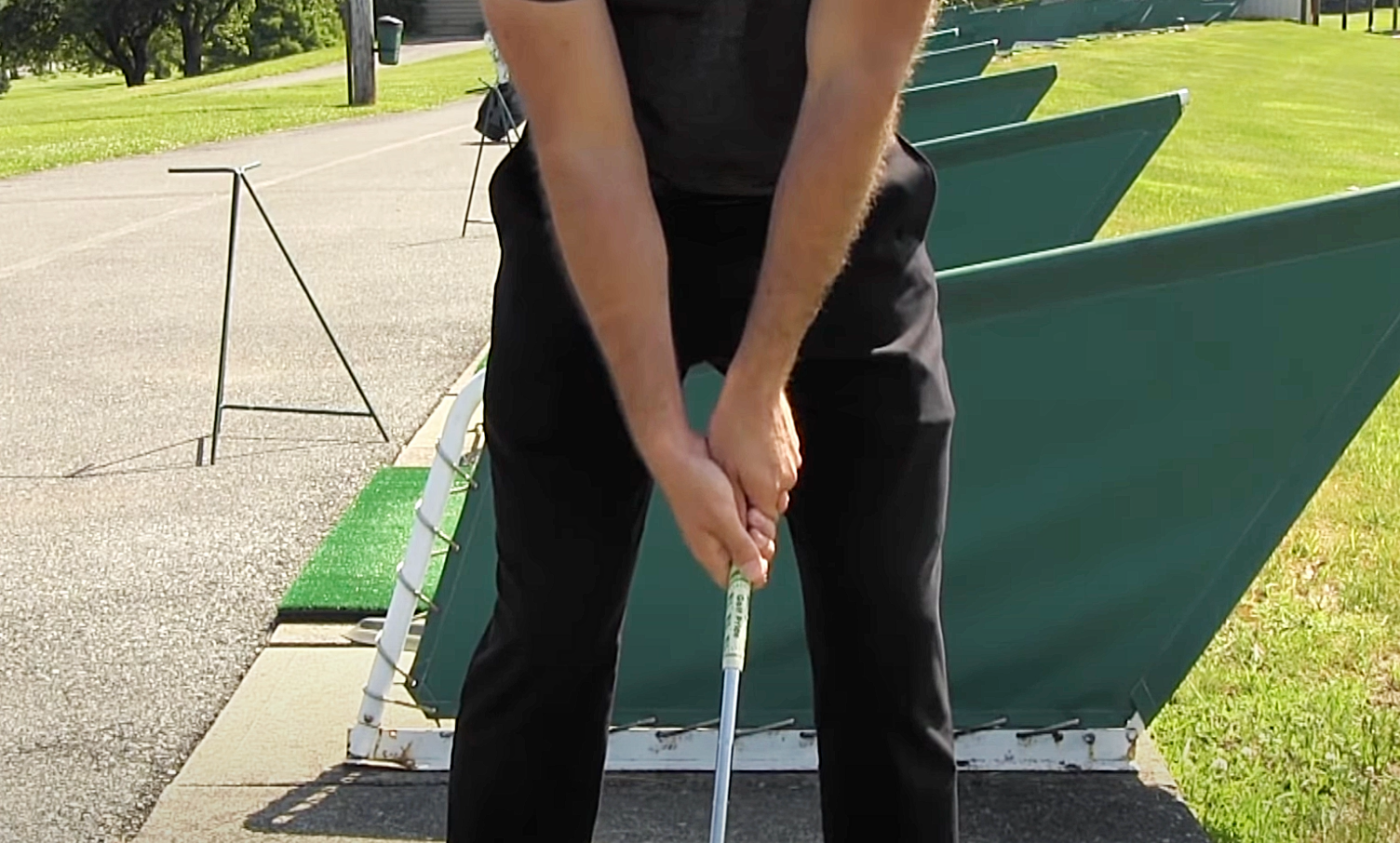 A golf coach showcasing an example of a strong golf club grip.