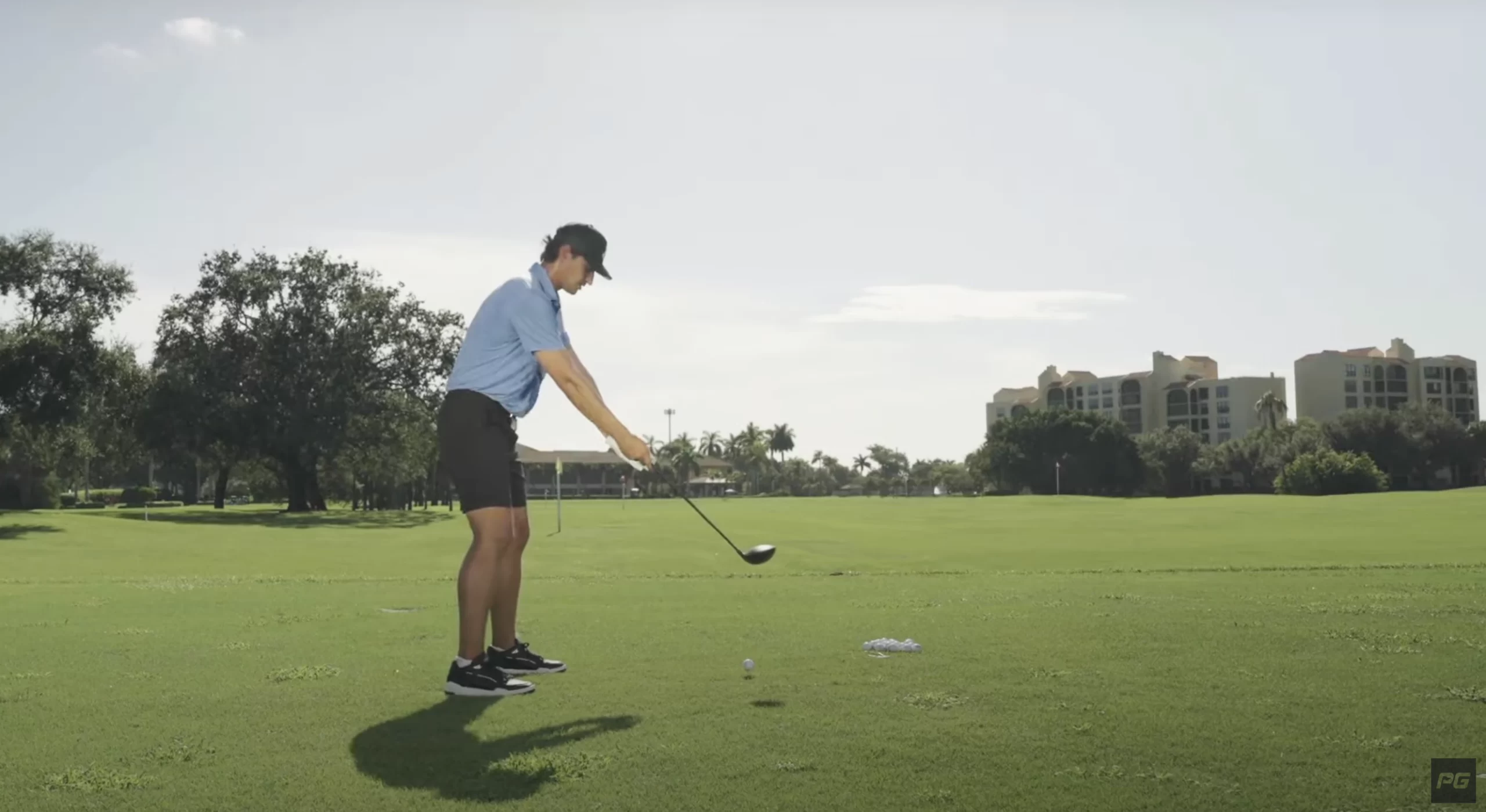 Performance Golf coach JT Thomas holding a golf club outward from his chest in a golf swing drill.