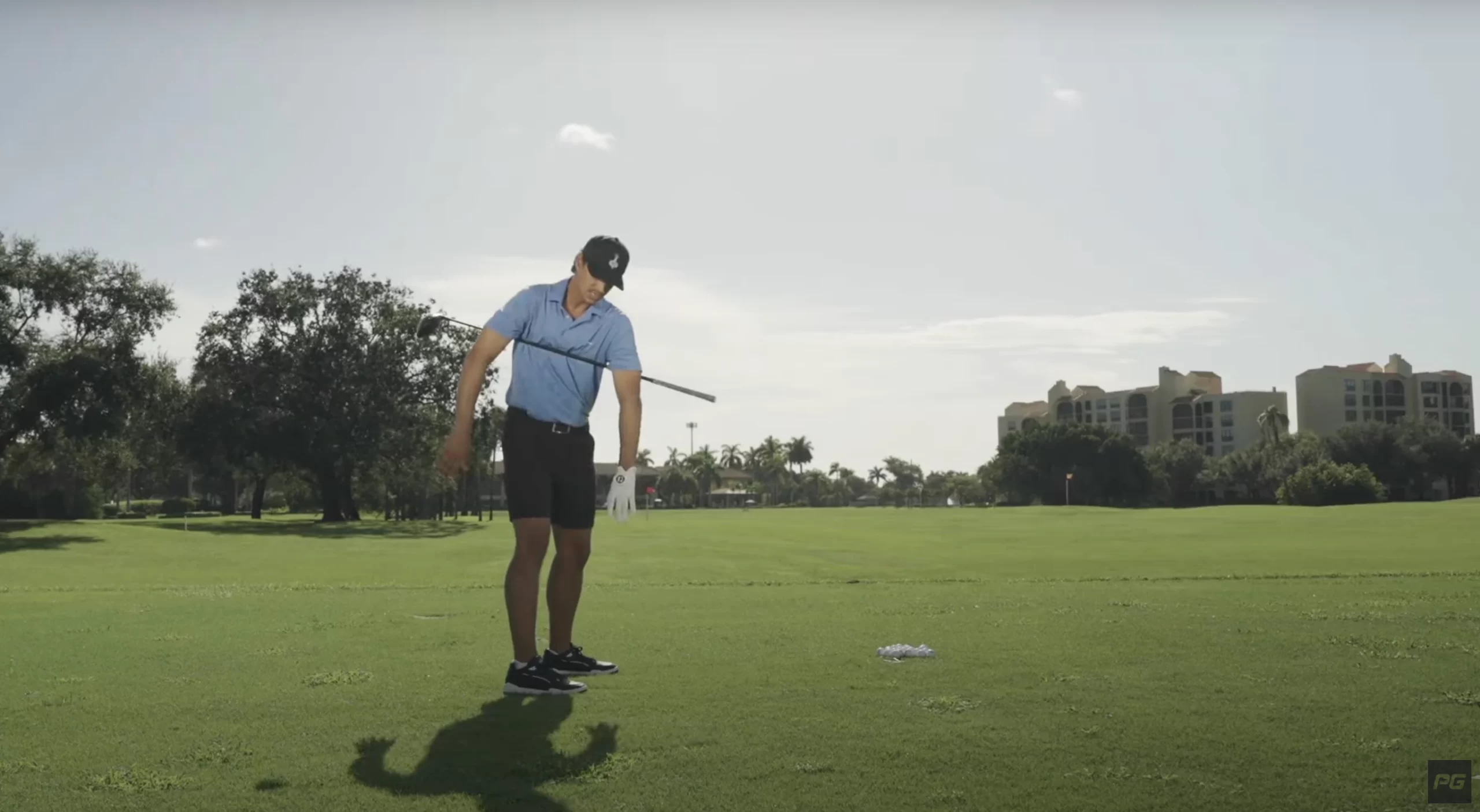 Performance Golf coach JT Thomas with a golf club across his chest and under his arms to demonstrate a drill.