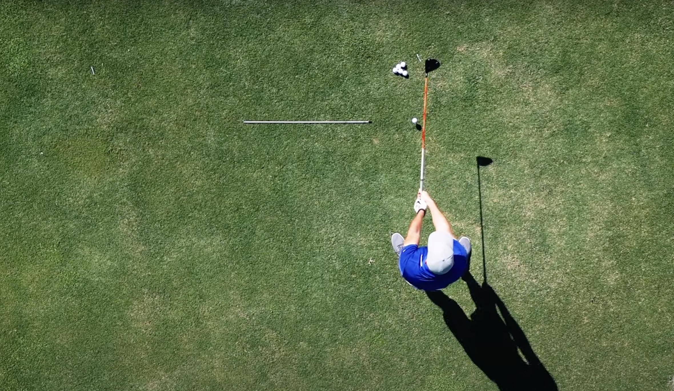 An aerial view of Performance Golf coach Eric Cogorno holding a golf club parallel to the ground like a baseball bat.