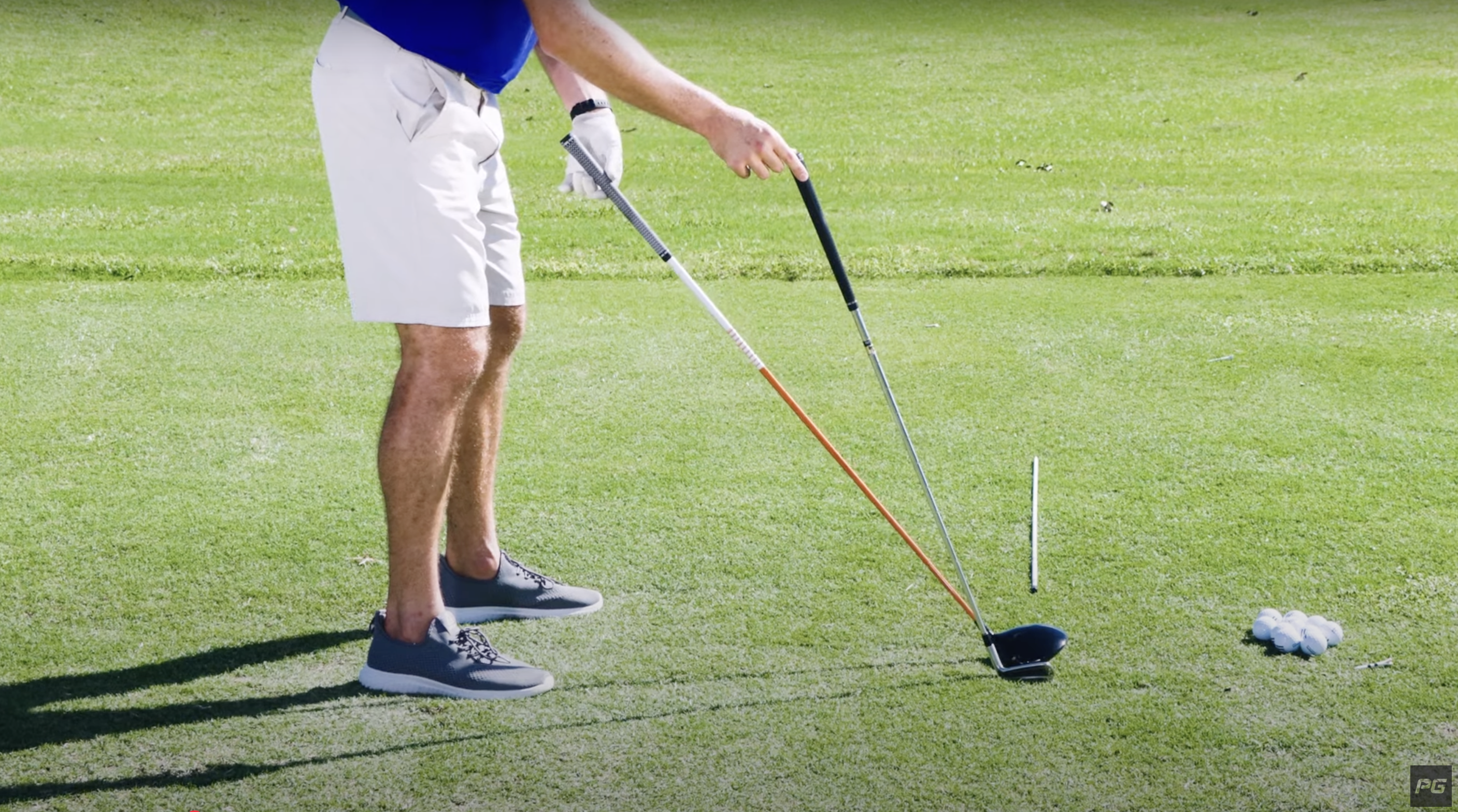 Performance Golf Coach Eric Cogorno showing the differences between the two golf clubs: an iron and a driver.