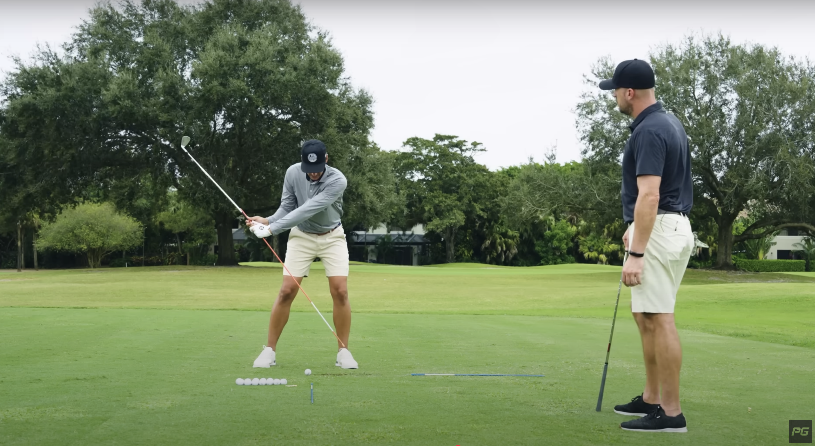 Two golfers practicing a contact drill.